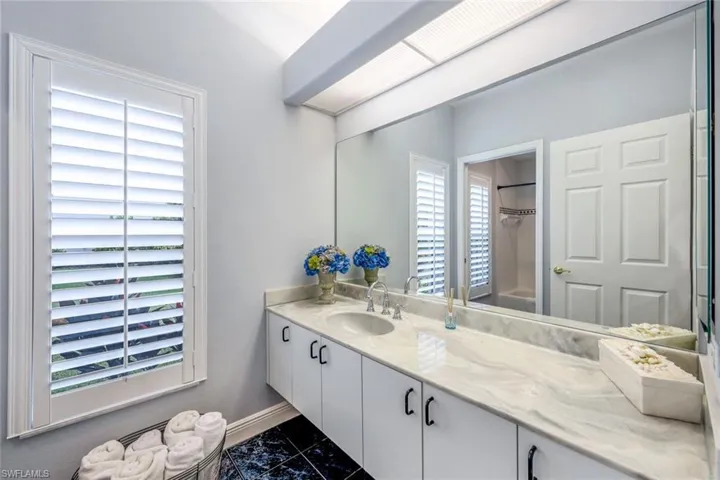 Bathroom featuring tile floors and vanity with extensive cabinet space