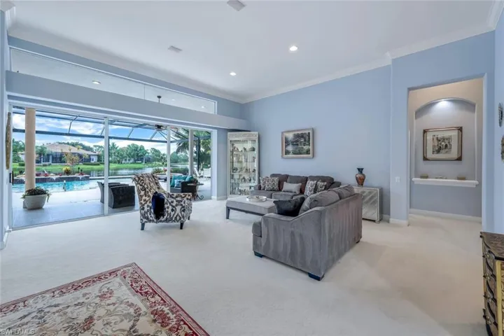 Living room with ornamental molding and light colored carpet