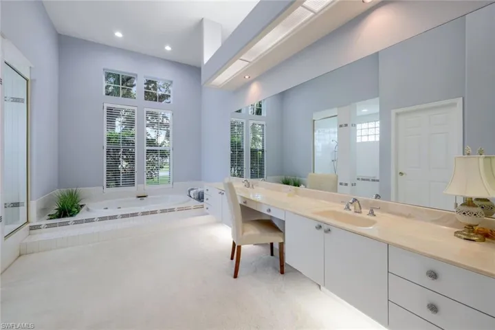 Bathroom featuring shower with separate bathtub and double sink vanity