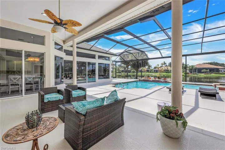 View of swimming pool featuring ceiling fan, a lanai, and a patio
