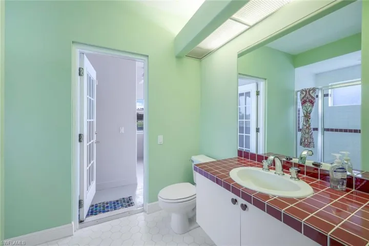 Bathroom featuring curtained shower, tile flooring, toilet, and large vanity