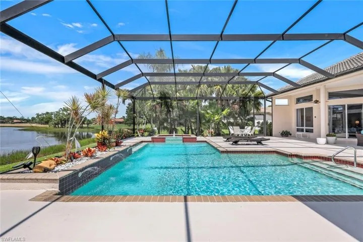 View of pool featuring glass enclosure and a patio area