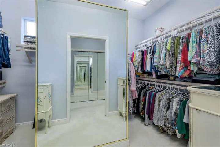 Spacious closet with light colored carpet