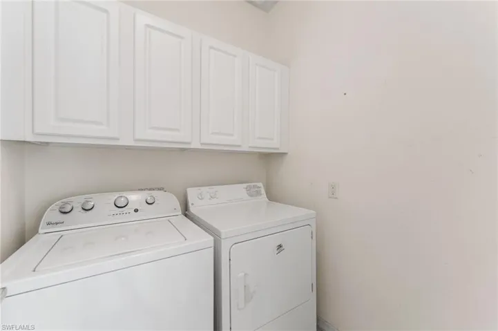 Clothes washing area with cabinets and washer and clothes dryer