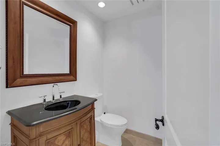 Half bathroom with vanity, recessed lighting, and light tile patterned floors