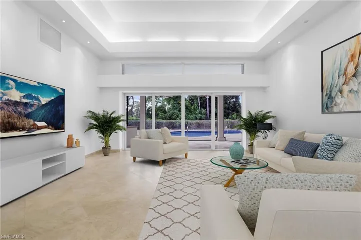 Living area featuring a raised ceiling and a towering ceiling Virtually Staged