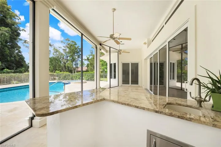 Unfurnished sunroom featuring a sink and a pool