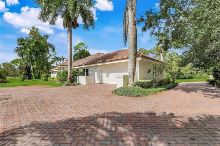 View of front of house with a garage, stucco siding, decorative driveway, and a tiled roof