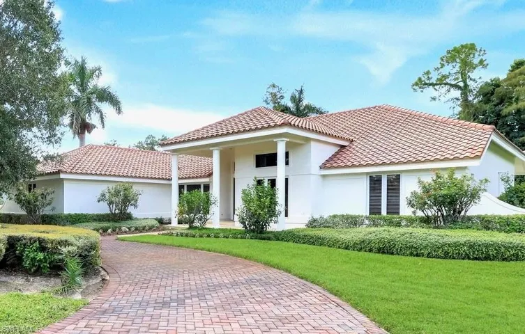 View of front facade featuring a front yard, stucco siding, and a tile roof