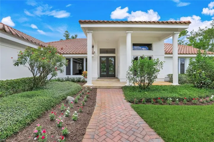 Doorway to property featuring a tile roof, french doors, stucco siding, and covered porch