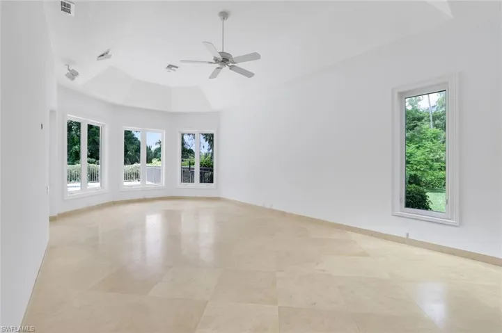 Primary Bedroom featuring a raised ceiling and ceiling fan