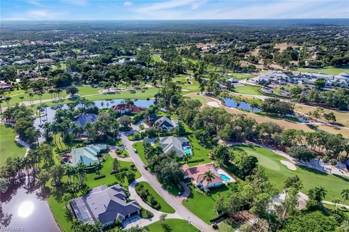 Aerial overview of property's location featuring nearby suburban area, a large body of water, and a golf club