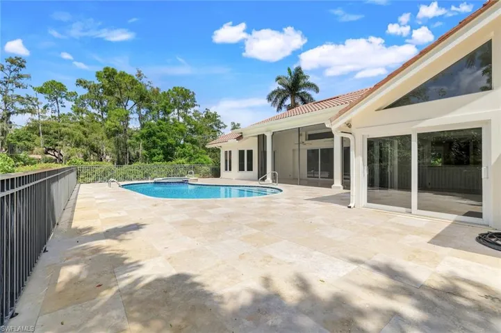 View of pool featuring a patio, a pool with connected hot tub, and a sunroom