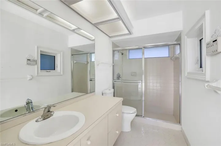 Pool Bathroom with a stall shower, vanity, and light tile patterned floors