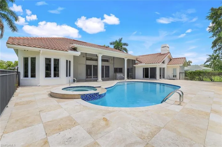View of swimming pool with a pool with connected hot tub, a patio, and a sunroom