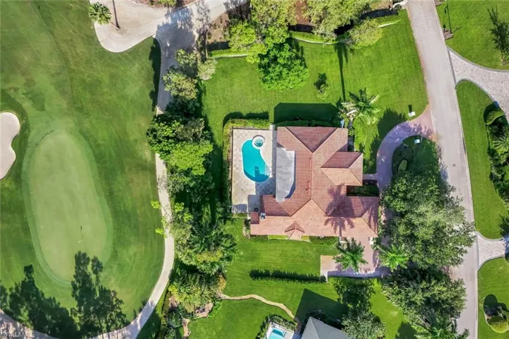 Drone / aerial view of a pool area and a golf course