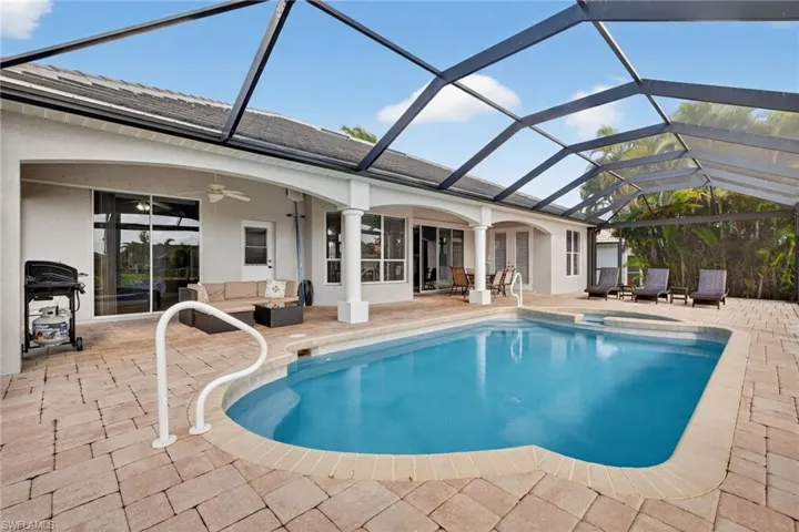 Integrated pool / spa with a sunroom, outdoor furniture, a lanai, a patio, and grilling area