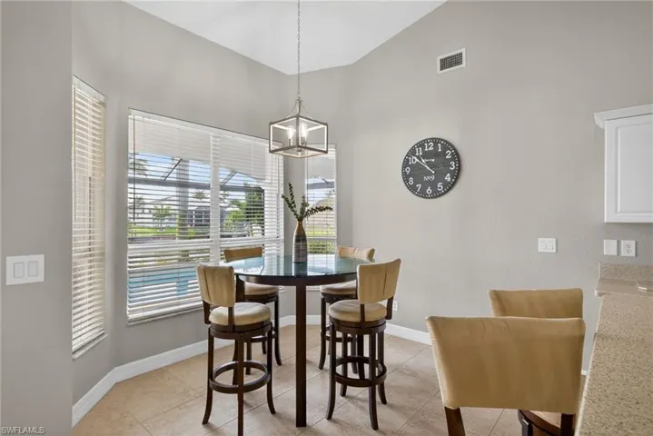 Dining space featuring vaulted ceiling, a chandelier, and light tile patterned floors