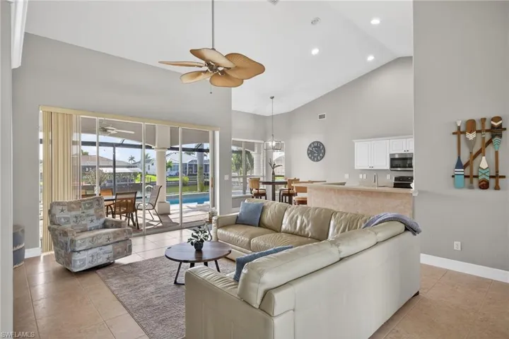 Living room featuring a sunroom, a ceiling fan, recessed lighting, vaulted ceiling, and light tile patterned flooring