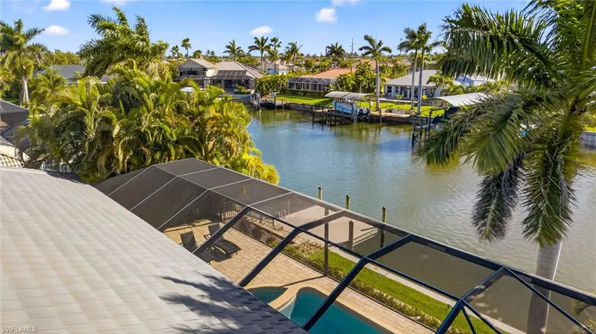 Dock area with a lanai, a water view, an outdoor pool, a sunroom, and a residential view