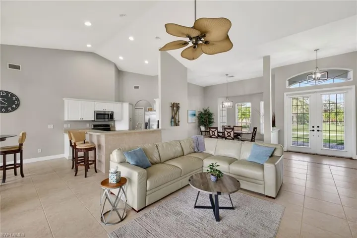 Living room featuring french doors, ceiling fan, vaulted ceiling, and recessed lighting