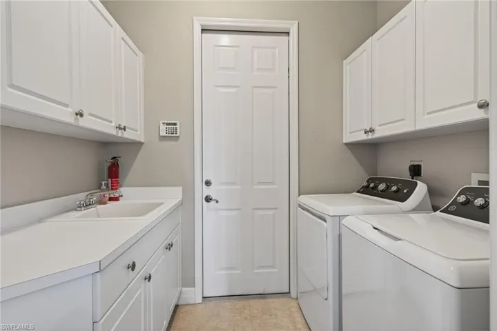 Laundry area with separate washer and dryer and cabinet space