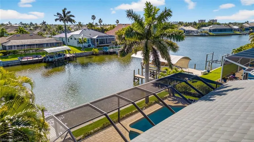 Dock area with a residential view, glass enclosure, a water view, and boat lift