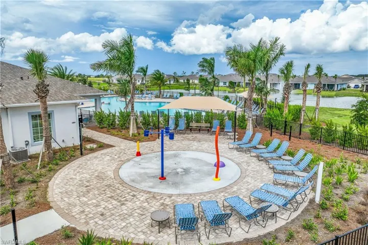 View of playground featuring a community pool, a water view, central AC, and a patio