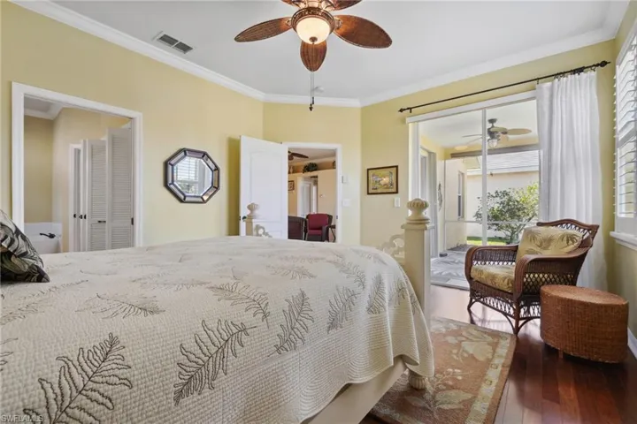 Bedroom with visible vents, ceiling fan, access to exterior, wood-type flooring, and crown molding