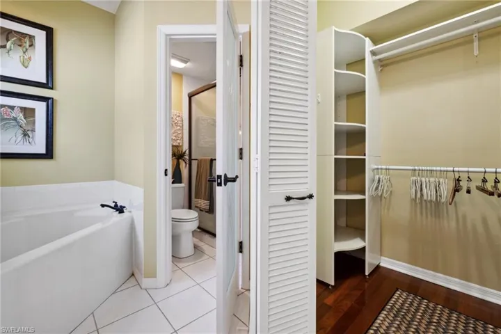 Full bathroom featuring a garden tub, toilet, a closet, and tile patterned floors