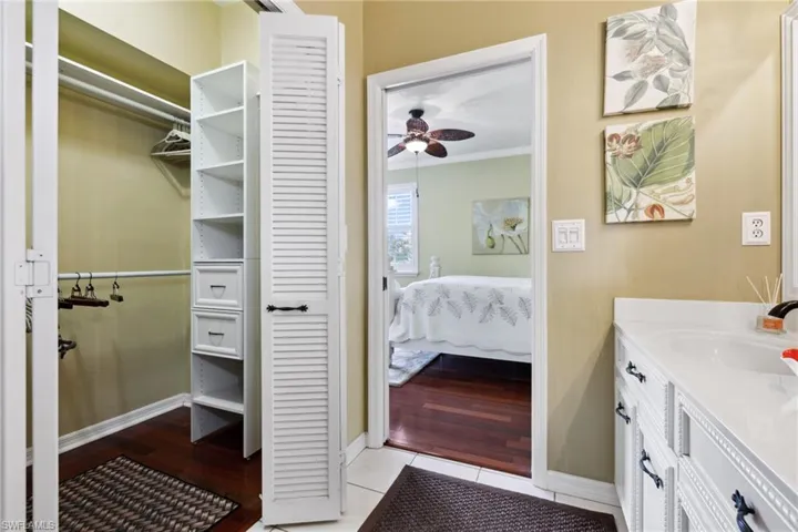 Ensuite bathroom with vanity, a ceiling fan, baseboards, ensuite bath, and ornamental molding