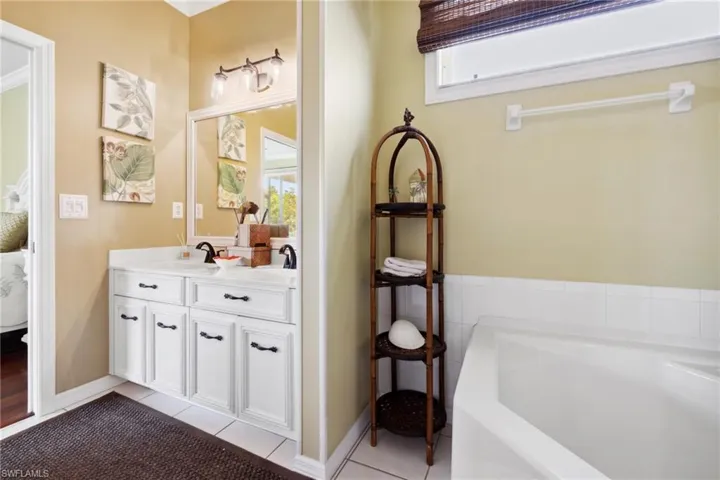 Full bathroom with a bath, tile patterned flooring, a sink, and double vanity