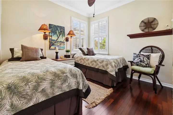 Bedroom with ornamental molding, baseboards, and hardwood / wood-style flooring