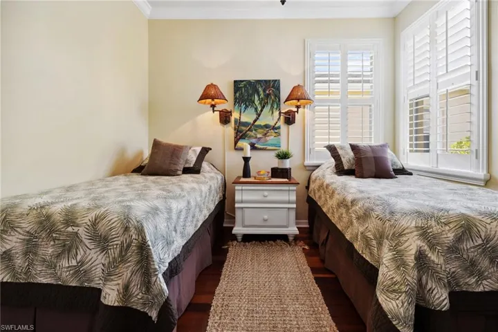 Bedroom featuring wood finished floors and ornamental molding