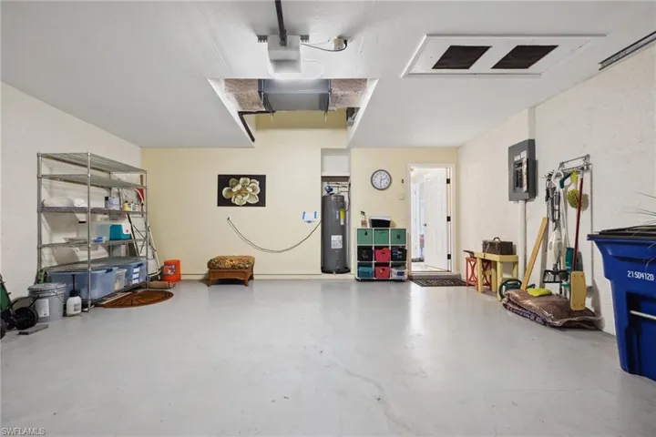 Garage featuring electric panel and electric water heater