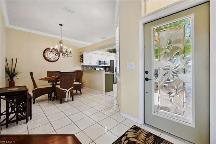 Dining room featuring visible vents, baseboards, ornamental molding, light tile patterned flooring, and a notable chandelier