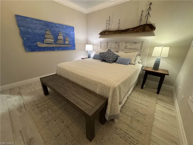 Bedroom with crown molding and light wood-style flooring