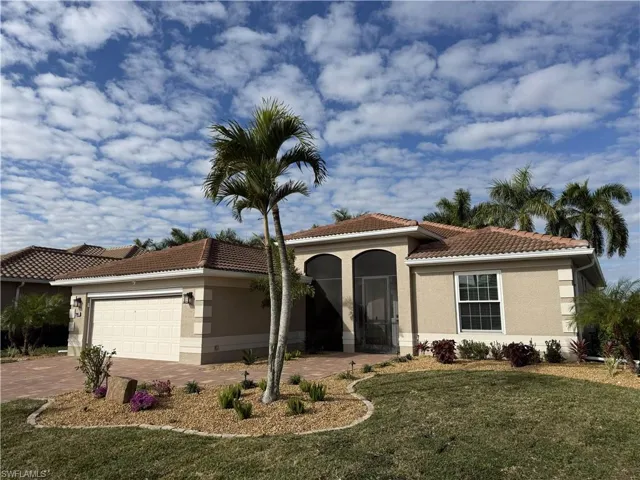 Mediterranean / spanish-style home with a garage, a tile roof, driveway, and stucco siding