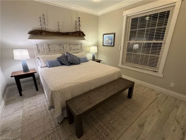 Bedroom with ornamental molding and light wood-style flooring