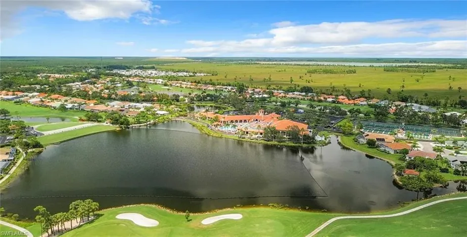 Aerial view of residential area with a nearby body of water and a golf course