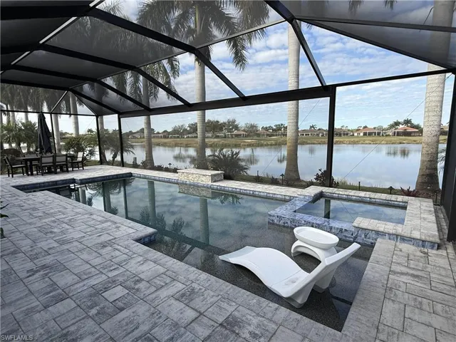 Integrated pool / spa featuring a sunroom, a lanai, a residential view, a water view, and outdoor dining space