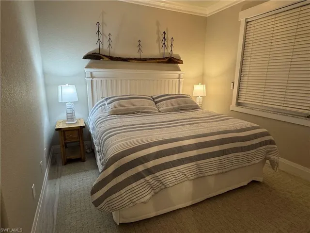 Bedroom with crown molding and a textured wall