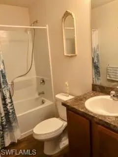 Full bathroom with wood-type flooring, toilet, shower / bathtub combination with curtain, and vanity
