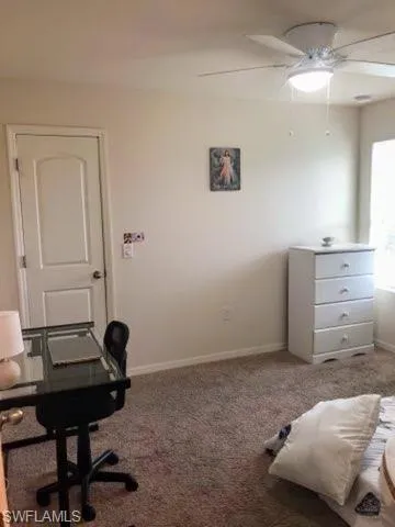 Carpeted bedroom featuring ceiling fan