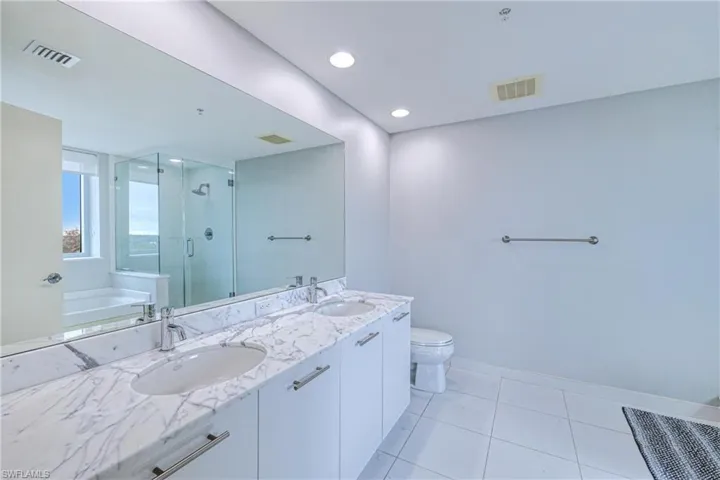 Full bathroom with tile patterned floors, plus walk in shower, vanity, and toilet