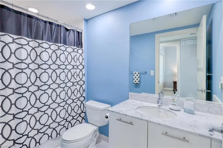 Bathroom with toilet, a shower with curtain, and vanity