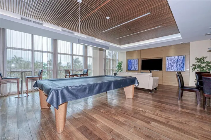 Game room with a raised ceiling, billiards, hardwood / wood-style floors, floor to ceiling windows, and wood ceiling