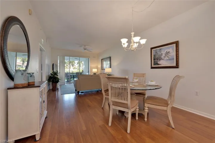 Dining room with hardwood / wood-style flooring and ceiling fan with notable chandelier