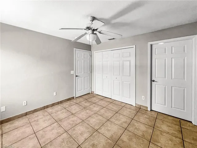 Spacious room featuring neutral-toned walls and square tile flooring