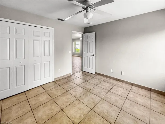 Neutral tone wall color with a white ceiling fan and light fixture